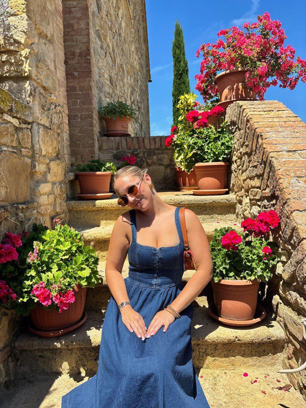 Alex Severs in jean dress wearing sunglasses.