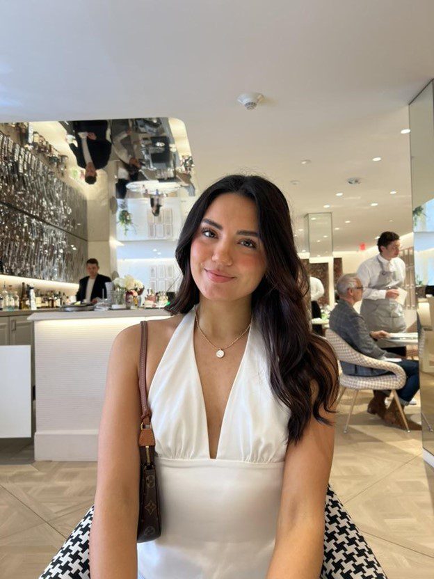 Picture of Andrea Aguilar in white at coffee shop.