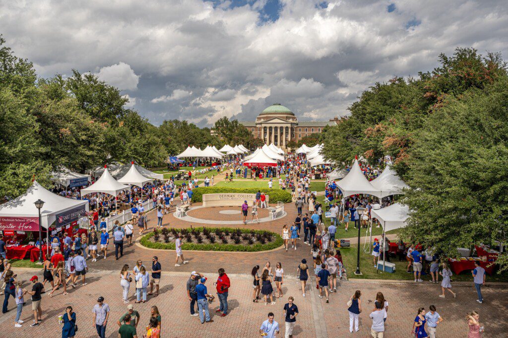 Boulevard at SMU. Lots of students and alumni walking around. Tents are up full of people.