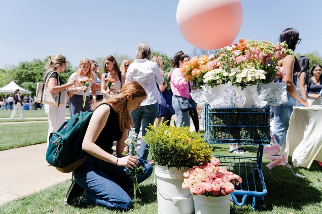 Student is bent down by flower bouquet during PerunaPalooza. 